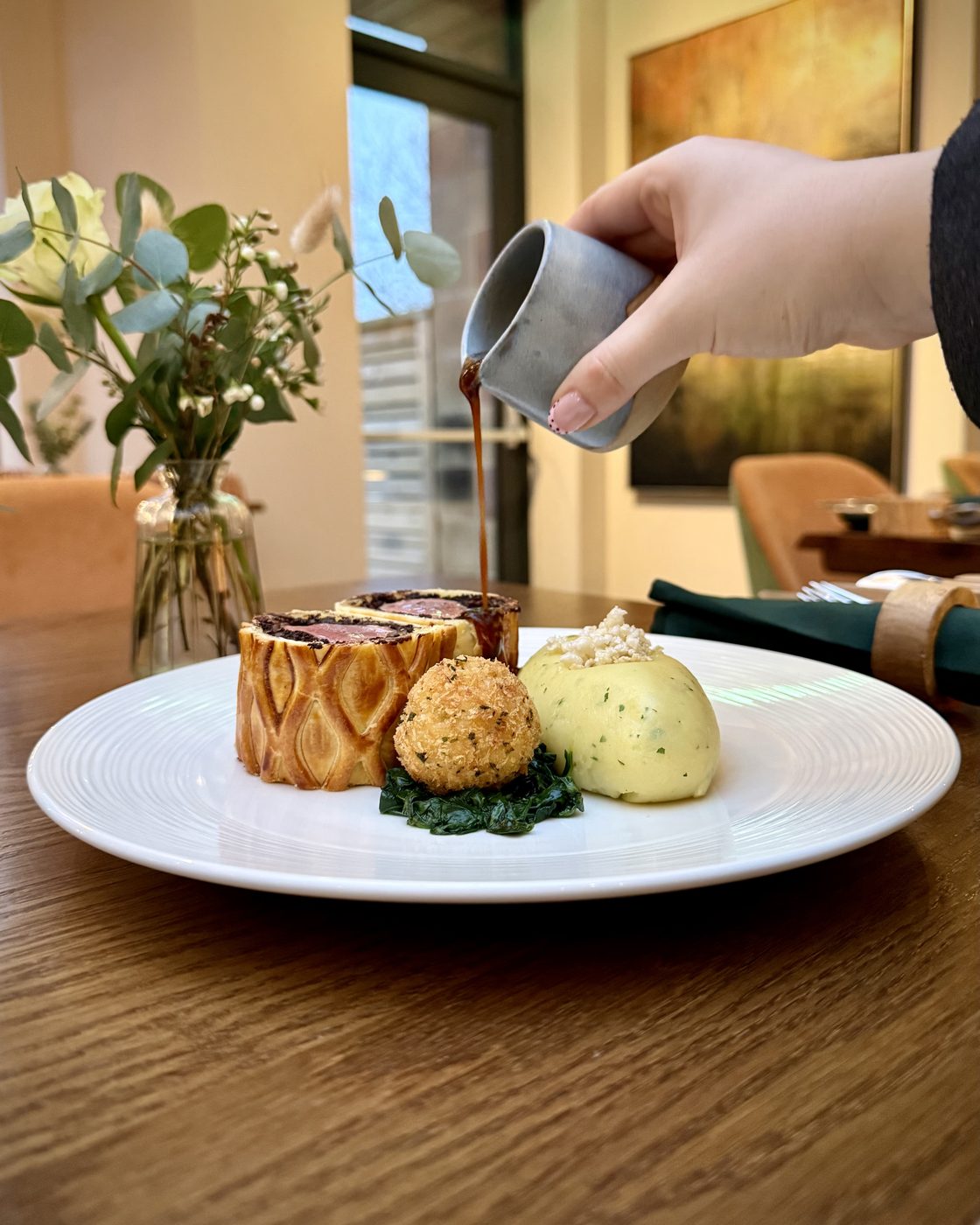 A plated dish finished at the table in the Riverside dining room